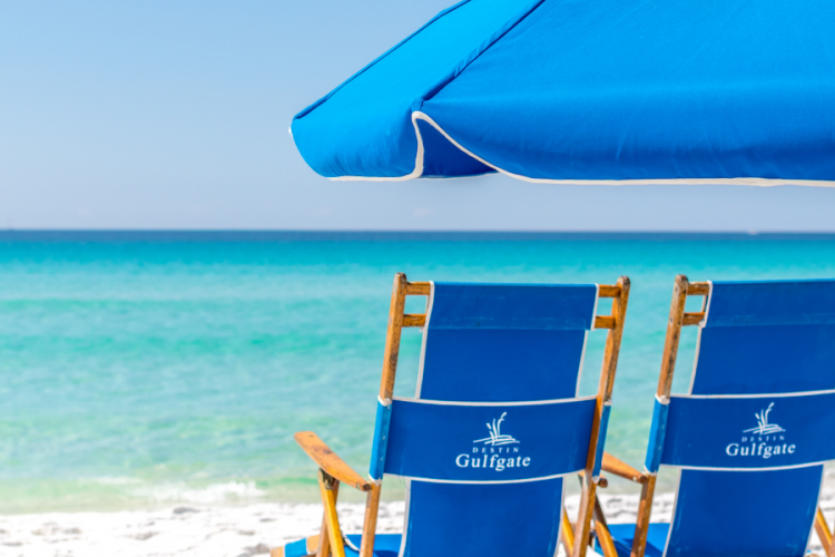 Two Destin Gulfgate beach chairs sit on the beach facing the water