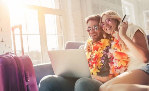 A happy couple plans a tropical vacation